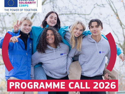 Gruppe junger Menschen, die sich umarmen und lachen. Im Hintergrund Bäume