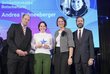Zwei Frauen und zwei Männer stehen auf einer Bühne, eine Frau hält einen Pokal in der Hand