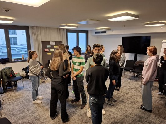 Junge Menschen stehen im Kreis 