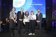 Europa bewegt: Erasmus+ und ESK Award 2024 Gruppenfoto von drei Frauen und zwei Männern auf einer Bühne, dahinter ein Screen mit dem Schriftzug „Innsbruck Solidarity Library“