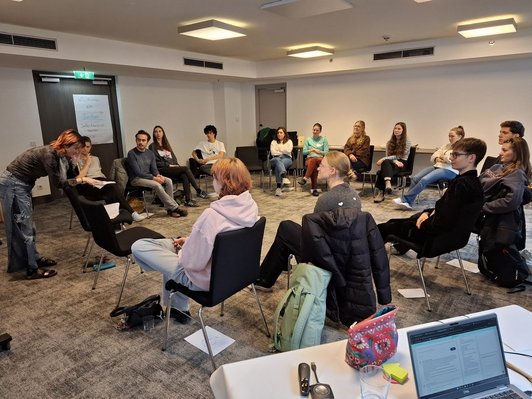Junge Menschen sitzen im Kreis 