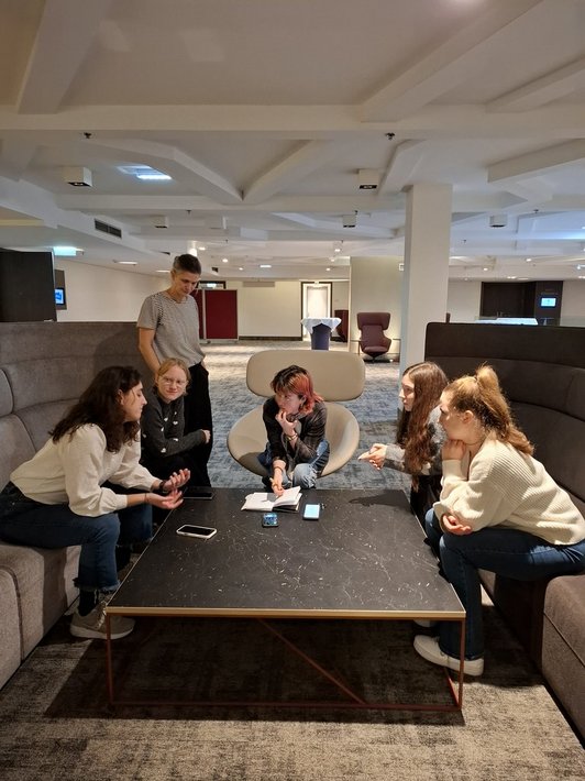 Junge Menschen sitzen im Kreis 