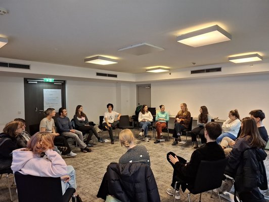 Junge Menschen sitzen im Kreis 